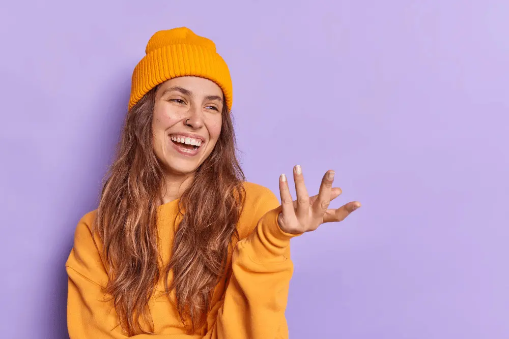 Woman wearing yellow sweater and yellow hat in purple background